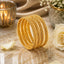 Gold-Tone Twisted Rope Textured Bangle Set of 4 on marble surface with candle, white rose and baby's breath flowers backdrop