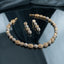 CZ Micro-Pavé Ball Filigree Disc Choker Necklace Earrings Set in Gold Two-Tone — flat-lay of two-tone gold filigree disc and silver CZ pavé ball choker collar with matching 4-drop earrings on dark grey silk mirror surface editorial backdrop