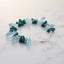Bracelet with deep green chip-shaped beads, pale aqua-blue rounded beads, clear accents, and a silver-tone clasp and extender chain.
