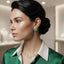 Model wearing rounded-square green and clear-looking striped stud earrings with a gold-tone appearance.
