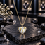 Gold-tone heart pendant with diagonal bands of clear sparkling accents, suspended from a coordinating link chain.