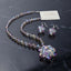 Beaded necklace with an iridescent clear-and-lavender floral cluster pendant and matching cluster drop earrings.