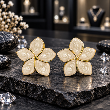 Pair of ivory five-petal flower earrings with pointed oval-style petals, glossy swirled patterns and thin gold-tone borders displayed on dark slate.