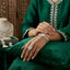 Kundan Pearl Hath Phool Bracelet Ring Gold lifestyle shot worn on model hand near face with green saree showing antique gold-tone kundan polki flower wrist station with pear CZ petals faux pearl drop hand chain and matching finger ring