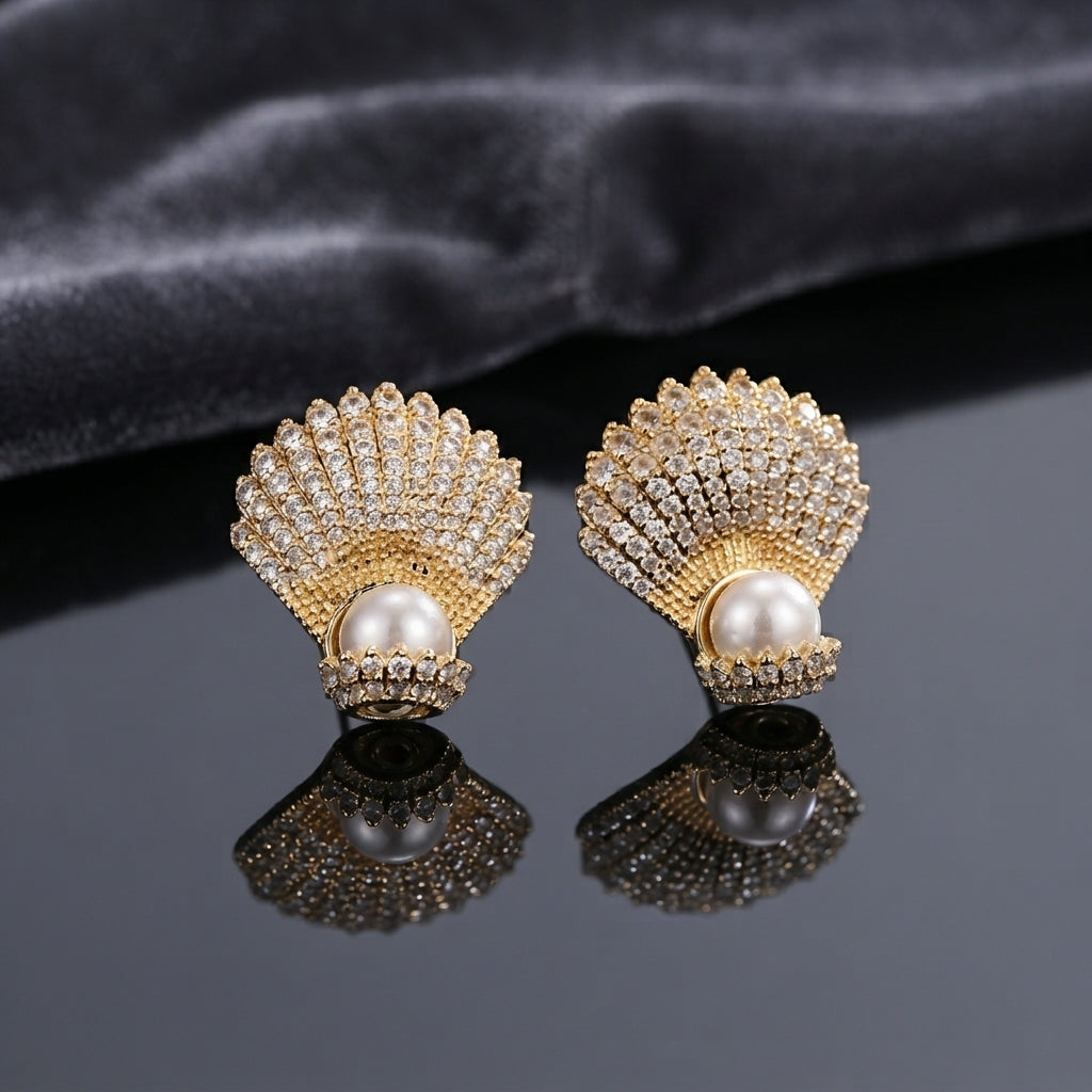 Micro Pavé CZ Seashell Faux Pearl Stud Earrings in silver-tone plating worn on model ear with beige stone background and teal blazer showing full CZ encrusted seashell design with large pearl at base