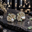 Pair of silver-tone cluster earrings with mint green accents, sparkling openwork panels, rectangular details and white iridescent pearl-look centres.