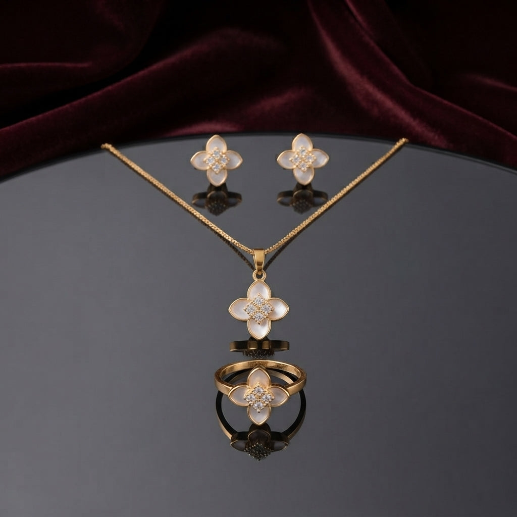 Mother of Pearl Clover Flower CZ Pavé Pendant Necklace Earrings and Ring Set in silver-tone flat lay on grey mirror surface with burgundy velvet backdrop showing 3-piece set with 4-petal clover flower design in white mother of pearl petal inlay and white CZ micro-pavé center cluster with mirror reflection