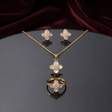 Mother of Pearl Clover Flower CZ Pavé Pendant Necklace Earrings and Ring Set in silver-tone flat lay on grey mirror surface with burgundy velvet backdrop showing 3-piece set with 4-petal clover flower design in white mother of pearl petal inlay and white CZ micro-pavé center cluster with mirror reflection