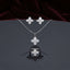 Mother of Pearl Clover Flower CZ Pavé Pendant Necklace Earrings and Ring Set in gold-tone flat lay on grey mirror surface with burgundy velvet backdrop showing 3-piece set with 4-petal clover flower design in white mother of pearl petal inlay and white CZ micro-pavé center cluster with mirror reflection