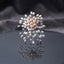 Multi-Tone Faux Pearl Starburst Spray Statement Brooch Pin flat lay on dark grey mirror surface with dark grey silk backdrop showing dandelion starburst spray brooch with round peach-pink faux pearl center cluster white oval pearl mid ring and mixed white lavender grey oval faux pearls on fine twisted silver-tone wire stems with mirror reflection below