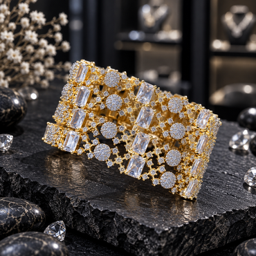Four matching gold-tone AD bangles with rectangular clear accents, round clusters of small clear accents and openwork connecting details on dark slate.