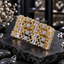 Four matching gold-tone AD bangles with rectangular clear accents, round clusters of small clear accents and openwork connecting details on dark slate.