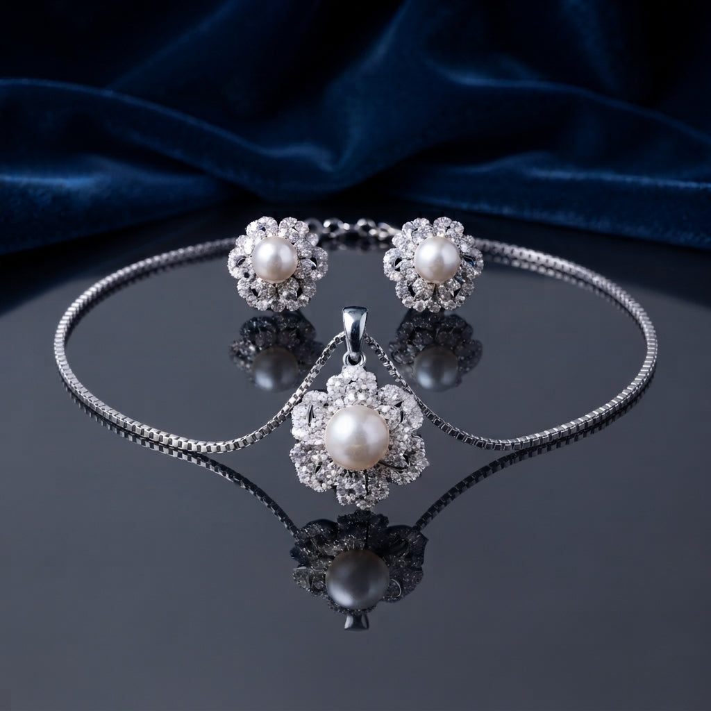 Pearl Center CZ Multi-Layer Floral Halo Pendant Necklace and Earrings Set in gold-tone flat lay on grey mirror surface with burgundy velvet backdrop showing 2-piece set with large cream pearl center in dense multi-layer white CZ floral sunburst halo pendant necklace and matching stud earrings with mirror reflection