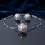 Pearl Center CZ Multi-Layer Floral Halo Pendant Necklace and Earrings Set in gold-tone flat lay on grey mirror surface with burgundy velvet backdrop showing 2-piece set with large cream pearl center in dense multi-layer white CZ floral sunburst halo pendant necklace and matching stud earrings with mirror reflection