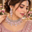Model wearing a pink floral bridal necklace set with matching earrings and maang tikka.