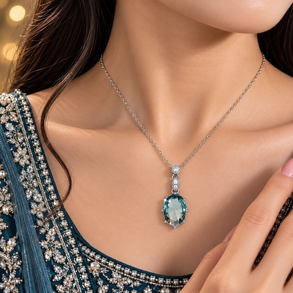Silver Aqua Teal Oval CZ Solitaire Drop Pendant Necklace worn by bridal model in teal crystal-embroidered lehenga with gold bokeh backdrop