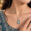 Silver Aqua Teal Oval CZ Solitaire Drop Pendant Necklace worn by bridal model in teal crystal-embroidered lehenga with gold bokeh backdrop
