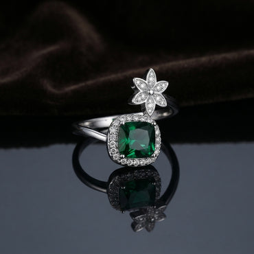 Silver Emerald Green Cushion CZ Halo Floral Crown Open Cocktail Ring on dark grey mirror surface with dark brown velvet drape backdrop