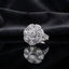 Silver CZ Art Deco Sunburst Flower Pear Petal Pavé Cocktail Ring in White — all-white CZ pear petals and round brilliant center on wide pavé split shank, luxury product shot on black mirror surface with dark charcoal silk backdrop