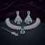 Silver CZ Cluster Choker Earrings and Maang Tikka Bridal Set in Emerald Green on dark mirror surface with purple velvet backdrop showing rhodium silver wide white CZ cluster choker with emerald green CZ square and pear pendant halo matching fan-drop earrings and maang tikka