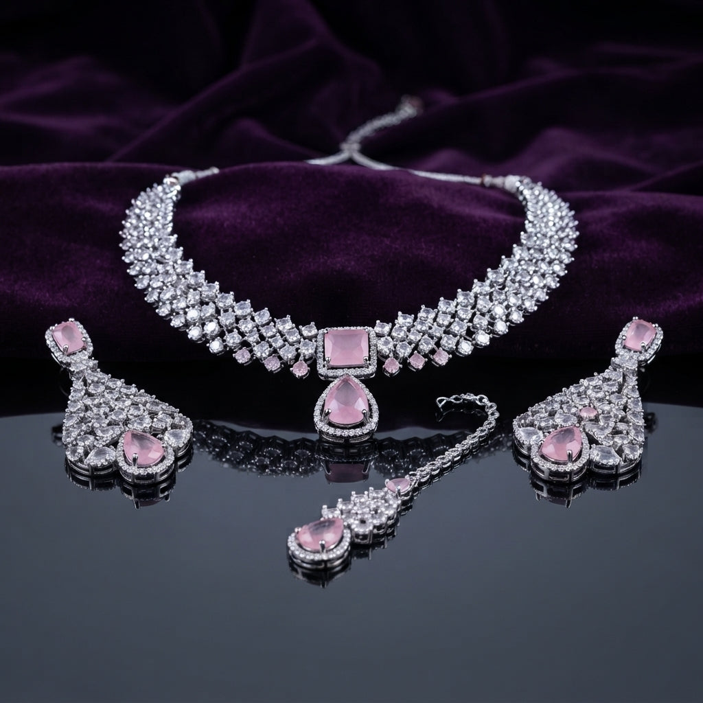 Silver CZ Cluster Choker Earrings and Maang Tikka Bridal Set in Rose Pink on dark mirror surface with purple velvet backdrop showing rhodium silver wide white CZ cluster choker with rose pink CZ square and pear pendant halo matching fan-drop earrings and maang tikka