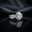 Silver CZ Statement Cocktail Ring in White Diamond — large oval brilliant white CZ halo center with white baguette CZ shoulder band on dark silk backdrop