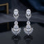 Silver CZ Double Teardrop Cabochon Lotus Fan Chandelier Earrings in Crystal Clear pair on dark mirror surface with navy blue backdrop showing rhodium-plated small crystal clear pear CZ stud with white CZ pave halo infinity connector and large crystal clear pear CZ drop with white CZ pave halo and marquise CZ lotus fan crown with mirror reflection below