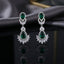 Silver CZ Double Teardrop Cabochon Lotus Fan Chandelier Earrings in Jet Black pair on dark mirror surface with grey velvet backdrop showing rhodium-plated small jet black pear cabochon stud with white CZ pave halo infinity connector and large jet black pear cabochon drop with white CZ pave halo and marquise CZ lotus fan crown with mirror reflection below