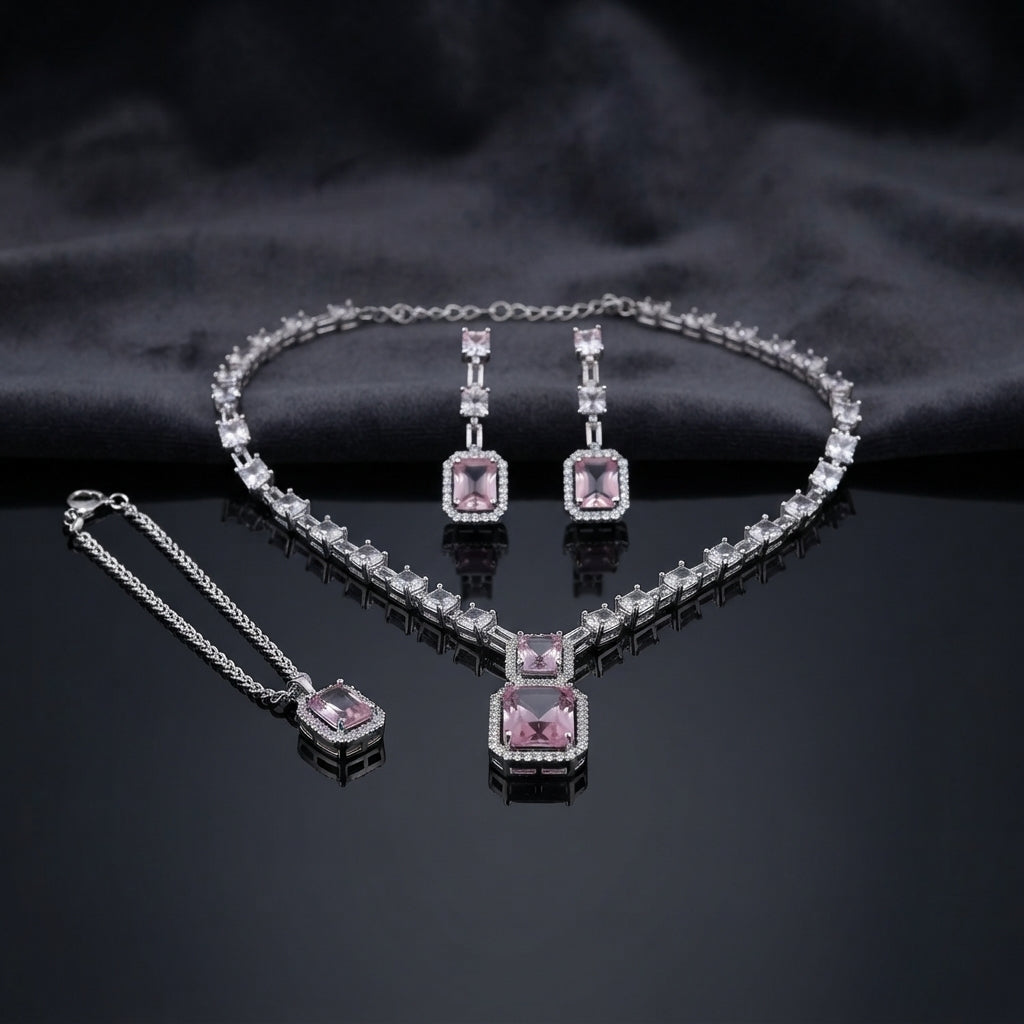 Silver CZ Emerald-Cut Baguette Tennis Necklace Earrings and Maang Tikka Set in Rose Pink on dark charcoal satin surface showing rhodium silver baguette CZ tennis necklace with double rose pink CZ halo pendant matching drop earrings and maang tikka