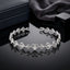 Silver-Tone CZ Filigree Heart Link Chain Bracelet on black mirror surface with navy leather jewelry box and charcoal grey silk fabric backdrop