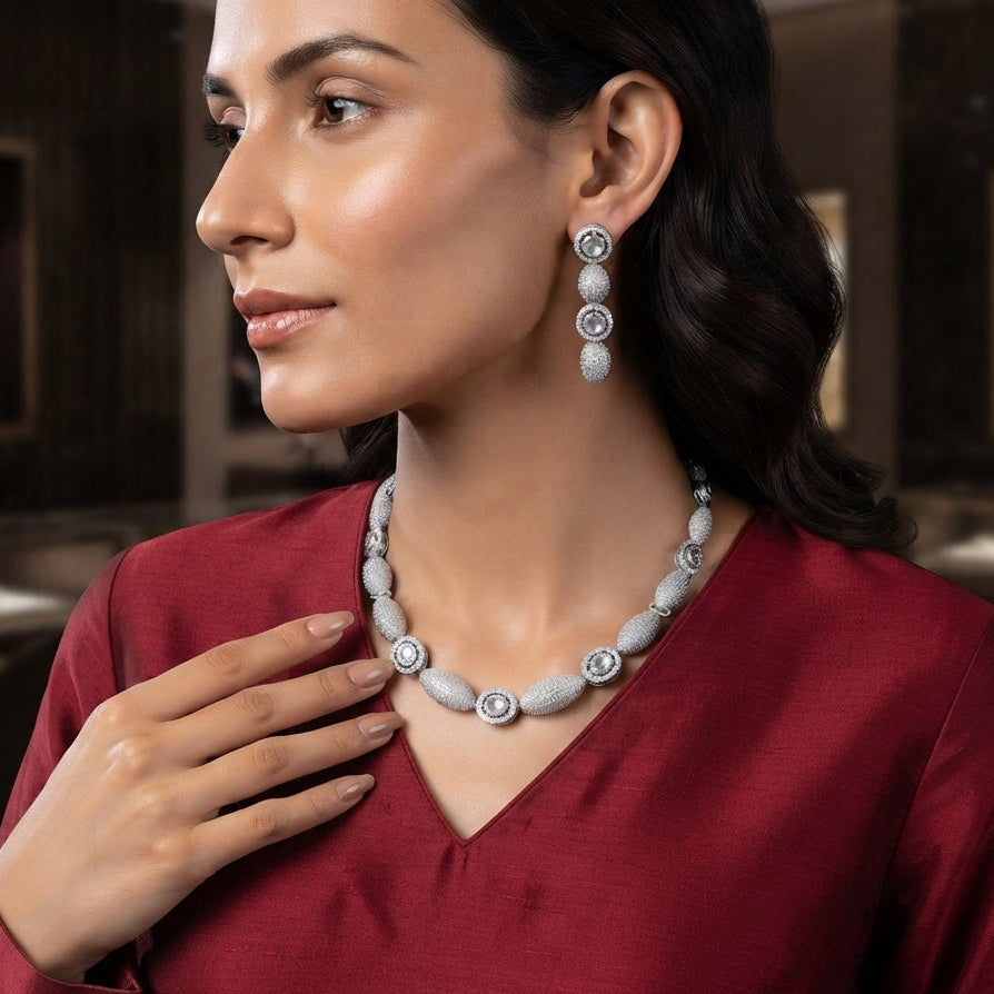 CZ Micro-Pavé Ball Disc Choker Necklace Earrings Set in Silver — model wearing rhodium-plated alternating oval CZ pavé ball bead and round solitaire disc choker necklace with matching 4-drop linear earrings, burgundy velvet backdrop in luxury jewelry boutique