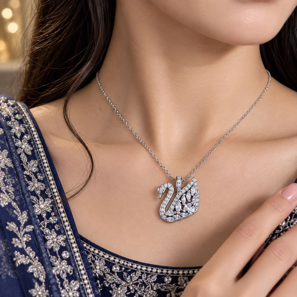 Silver CZ Marquise & Pavé Swan Pendant Bridal Necklace worn by bridal model in navy blue embroidered lehenga with gold bokeh backdrop