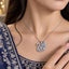 Silver CZ Marquise & Pavé Swan Pendant Bridal Necklace worn by bridal model in navy blue embroidered lehenga with gold bokeh backdrop