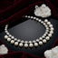Silver-Tone CZ Tennis & Pearl Drop Fringe Choker Necklace flat lay on black mirror surface with white quartz crystal clusters and deep burgundy velvet fabric backdrop