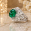 Silver-Tone Emerald Cabochon CZ Pavé Halo & Marquise Flower Statement Cocktail Ring on marble surface with gold candle lantern and white roses backdrop