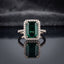 Silver Emerald Cut CZ Rectangular Halo Pave Band Solitaire Ring in Ruby Red variant on dark mirror surface with deep burgundy velvet backdrop showing vivid deep ruby red emerald-cut CZ solitaire in 4-claw setting with full rectangular white CZ halo and continuous micro-pave white CZ band in rhodium silver with mirror reflection below