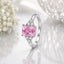 Silver-Tone Emerald-Cut Pink CZ Solitaire Ring with Triangle White CZ Accents on white reflective surface with baby's breath flowers backdrop