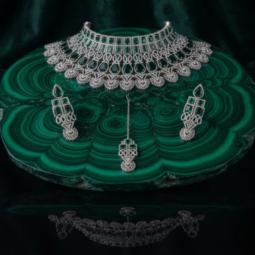 Silver Emerald Green CZ Art Deco Peacock Fan Wide Bib Choker Earrings & Maang Tikka Bridal Set on green malachite stone tray with dark green velvet drape backdrop