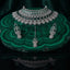 Silver Emerald Green CZ Art Deco Peacock Fan Wide Bib Choker Earrings & Maang Tikka Bridal Set on green malachite stone tray with dark green velvet drape backdrop