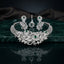 Silver Emerald Green CZ Botanical Floral Garden Statement Necklace & Earrings Bridal Set on dark green marble surface with grey silk drape backdrop