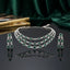 Silver Emerald Green CZ 3-Layer Emerald-Cut Tennis Necklace and Earrings Luxury Bridal Set on dark grey mirror surface with emerald green silk backdrop and fashion books showing triple-strand layered collar necklace with emerald-cut green CZ square halo stations and white CZ daisy rosette spacers flanked by matching 3-stone vertical drop earrings with mirror reflection below