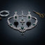 Silver-Tone Emerald Green CZ & White CZ Baguette Art Deco Fan Necklace Chandelier Earrings & Maang Tikka 3-Piece Bridal Set on black mirror surface with silver wire coil and antique gold scissors backdrop