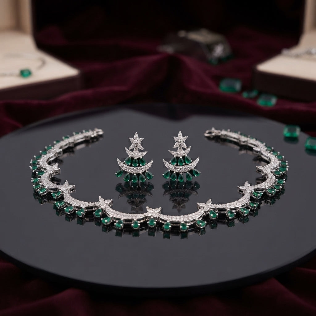 Silver Emerald Green CZ Crescent Moon Star Choker Necklace Earrings Set on black mirror display tray with burgundy velvet backdrop and scattered emerald green CZ stones showing rigid collar choker with repeating crescent moon motifs in emerald green oval round CZ and micro-pave white CZ with marquise star flower connectors and matching crescent moon drop earrings with graduated emerald green CZ fan and star marquise white CZ stud top with mirror reflections below