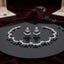 Silver Emerald Green CZ Crescent Moon Star Choker Necklace Earrings Set on black mirror display tray with burgundy velvet backdrop and scattered emerald green CZ stones showing rigid collar choker with repeating crescent moon motifs in emerald green oval round CZ and micro-pave white CZ with marquise star flower connectors and matching crescent moon drop earrings with graduated emerald green CZ fan and star marquise white CZ stud top with mirror reflections below