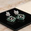 Silver Emerald Green CZ Cushion Pavé and White CZ Marquise Lotus Drop Earrings flat lay on mirror surface with marble backdrop showing pair detail with reflection of marquise lotus stud and emerald green CZ cushion pavé drop with white CZ cross grid overlay