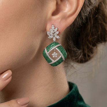 Silver Emerald Green CZ Cushion Pavé and White CZ Marquise Lotus Drop Earrings worn by model in emerald green velvet top showing full marquise white CZ lotus spray stud and large emerald green CZ cushion pavé drop with white CZ cross grid overlay and suspended flower charm