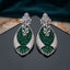Silver Emerald Green CZ Oval Cluster and Pearl Vine Twisted Leaf Grand Drop Earrings flat lay on dark mirror surface with teal velvet backdrop showing pair detail with reflection of white CZ lotus stud and dense oval emerald CZ twisted leaf drop with pearl vine overlay and stepped CZ base
