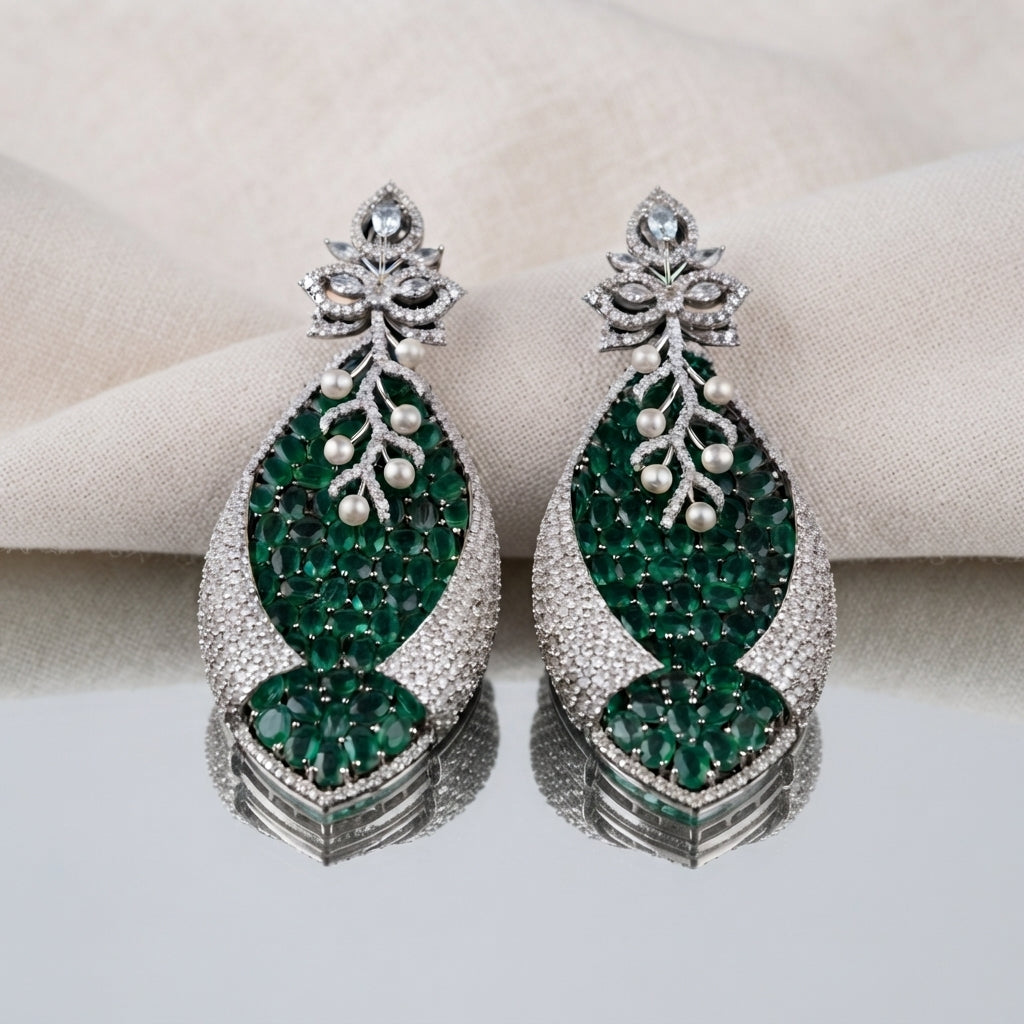 Silver Emerald Green CZ Oval Cluster and Pearl Vine Twisted Leaf Grand Drop Earrings worn by model in emerald green velvet top on grey backdrop showing grand statement drop earrings with lotus stud and twisted leaf emerald CZ cluster drop with pearl vine