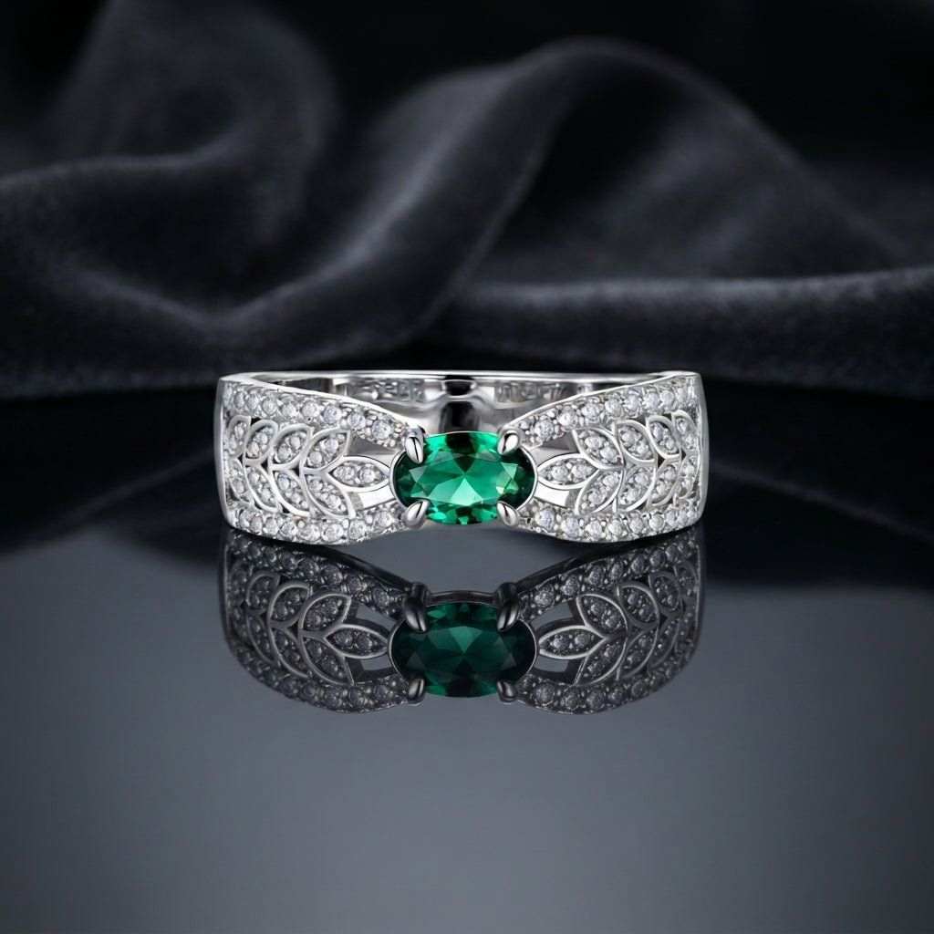 Silver Emerald Oval CZ Wide Leaf Openwork Pavé Band Cocktail Ring on dark grey mirror surface with dark grey satin drape backdrop