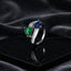 Silver Emerald Green & Royal Sapphire Blue Toi et Moi Pear CZ Baguette Bypass Cocktail Ring on black lacquer tray with dark grey satin drape backdrop